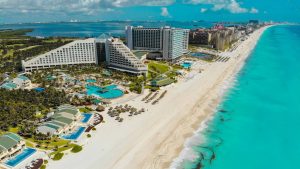Vista aérea de la zona hotelera de Cancún con hoteles frente al mar turquesa
